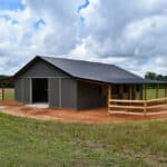 Horse barn built with post frame materials; two lean-to's, two sliding barn doors, six stalls, concrete floor