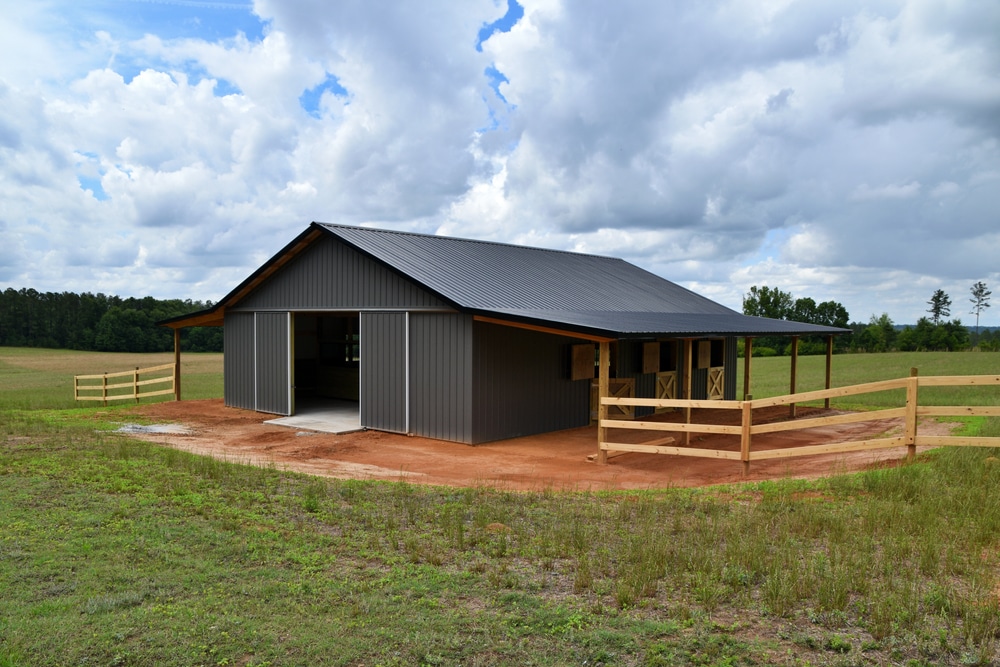 Horse barn built with post frame materials; two lean-to's, two sliding barn doors, six stalls, concrete floor